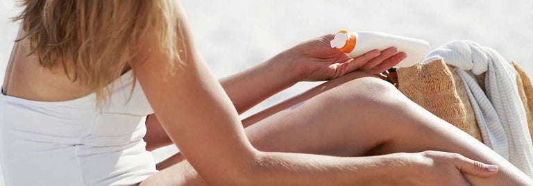 Women applying sunscreen to legs