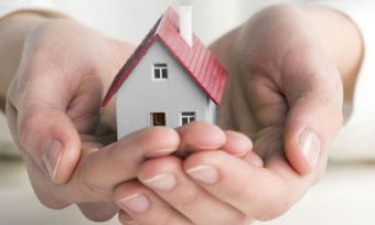 Person holding miniature house
