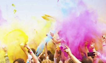 People dancing with coloured powder