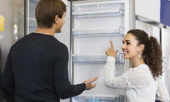 Women pointing at fridge to man