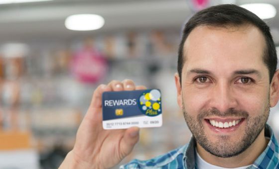 Man holding up loyalty program card