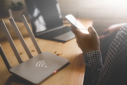 closeup of a wireless router and a man 